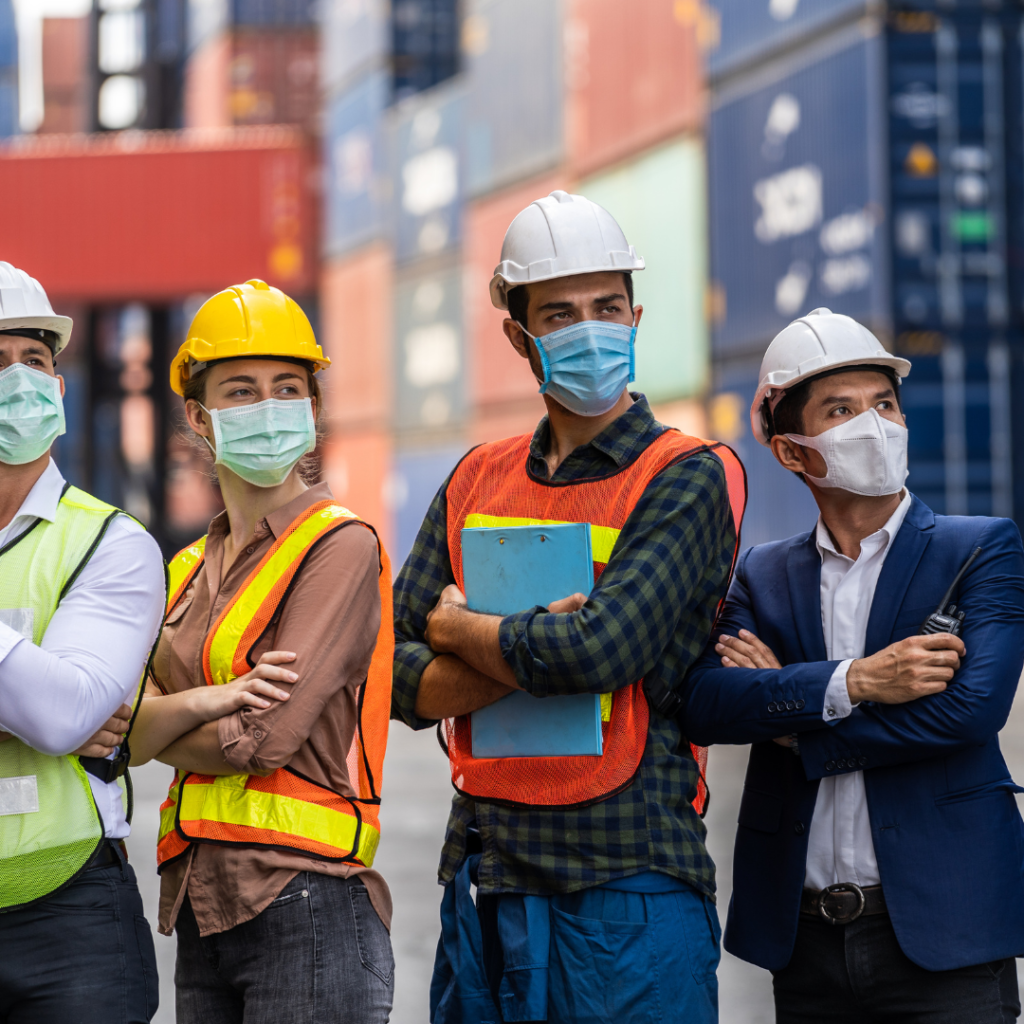 Australian logistics and construction team wearing hi-vis workwear and face masks on-site for workplace safety and compliance.